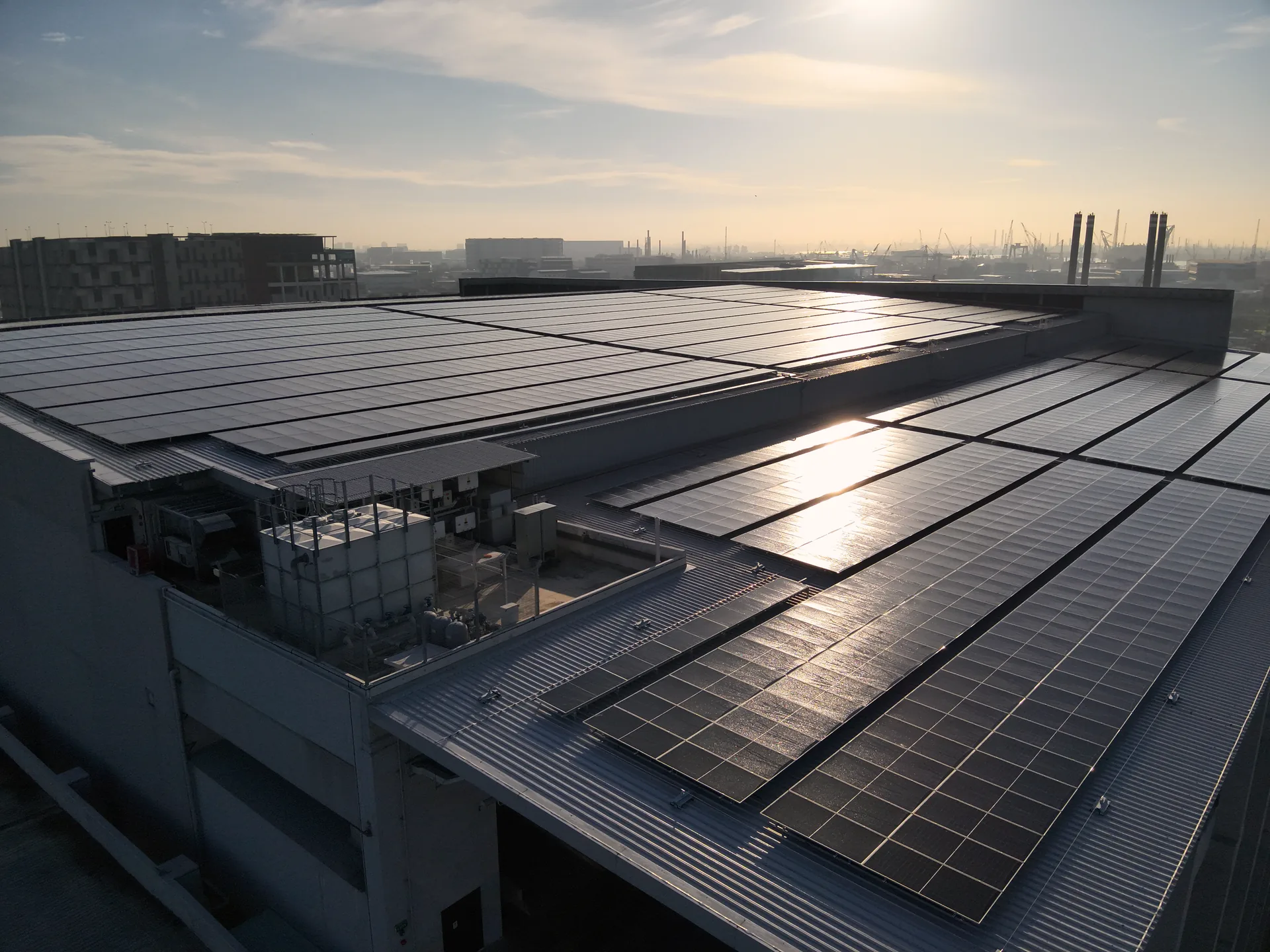 Talk to our engineers, Boustead 36 Tuas Road industrial rooftop solar at golden hour with Singapore Strait skyline